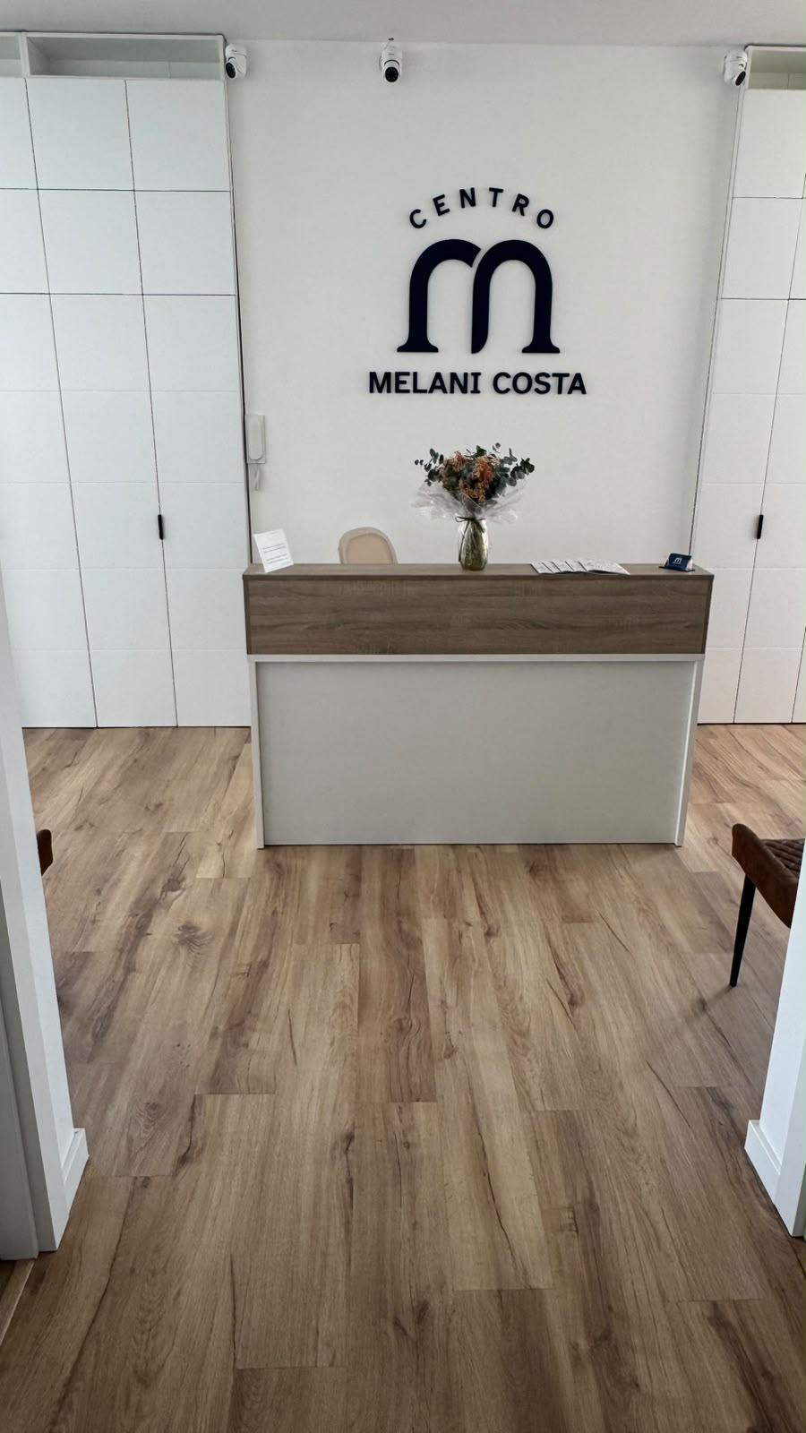 Recepción del Centro Melani Costa con el logo en la pared